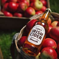 The Apple Farm view of a bottle of cider on a basket of red apples