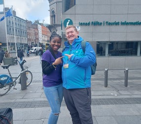 A tour guide and client posing on a city street