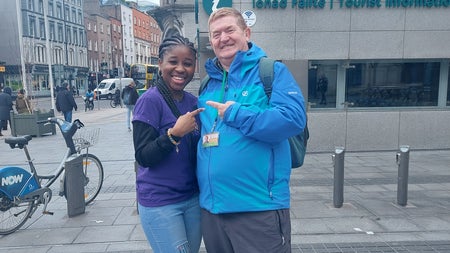 A tour guide and client posing on a city street