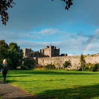 People walking on a path through a lawn outside Cahir Castle, Tipperary