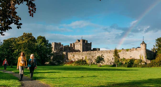 People walking on a path through a lawn outside Cahir Castle, Tipperary