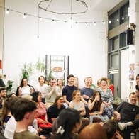 Seanchoíche Dublin in 2025, a woman holding a mic talking to a group of laughing people