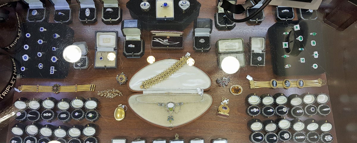 Large display of jewellery mainly rings and in centre gold bracelet and silver neckpiece