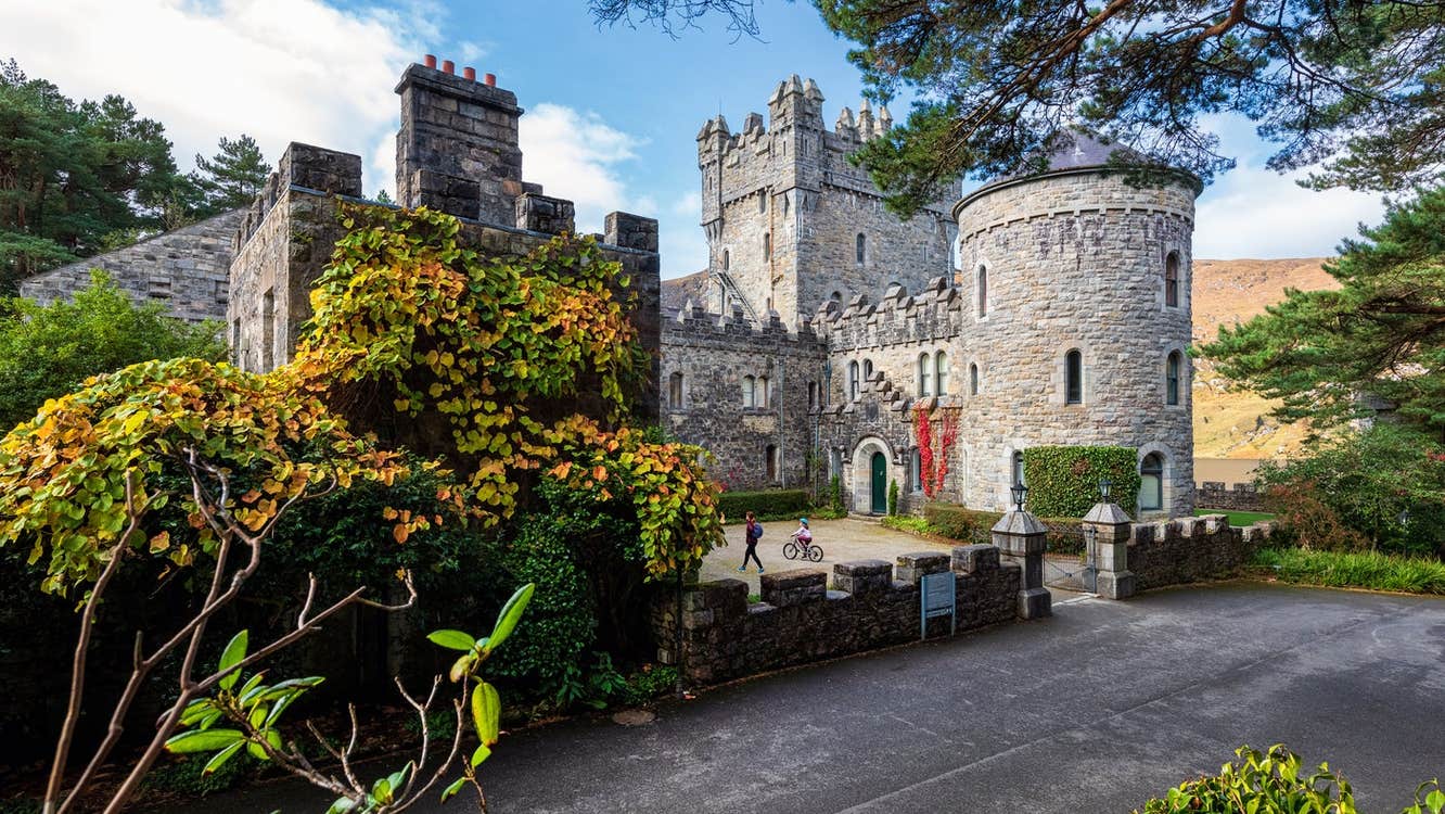 A castle and round tower surrounded by green shrubbery