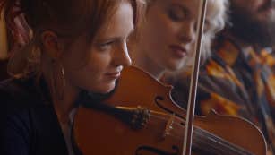 Close up view of young woman playing a violin