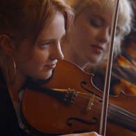 Close up view of young woman playing a violin
