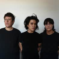 3 serious looking people all dressed in the same dark T-shirt, against plain grey background.