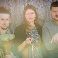 Slightly blurry photo of 3 musicians with instruments