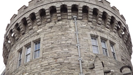 A close up of a stone circular tower that is part of a castle