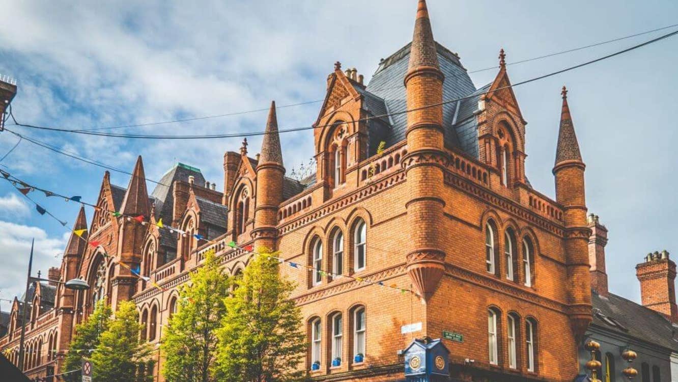 Historic red brick Victorian building with pointed turrets and arched windows