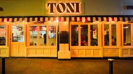 Image of TONI Italian restaurant in the evening with the outside lighting on