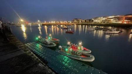 Four of the Dublin Boat Tour RIBs assembled alongside a pontoon in Dun Laoghaire Harbour with their navigation lights illuminated.