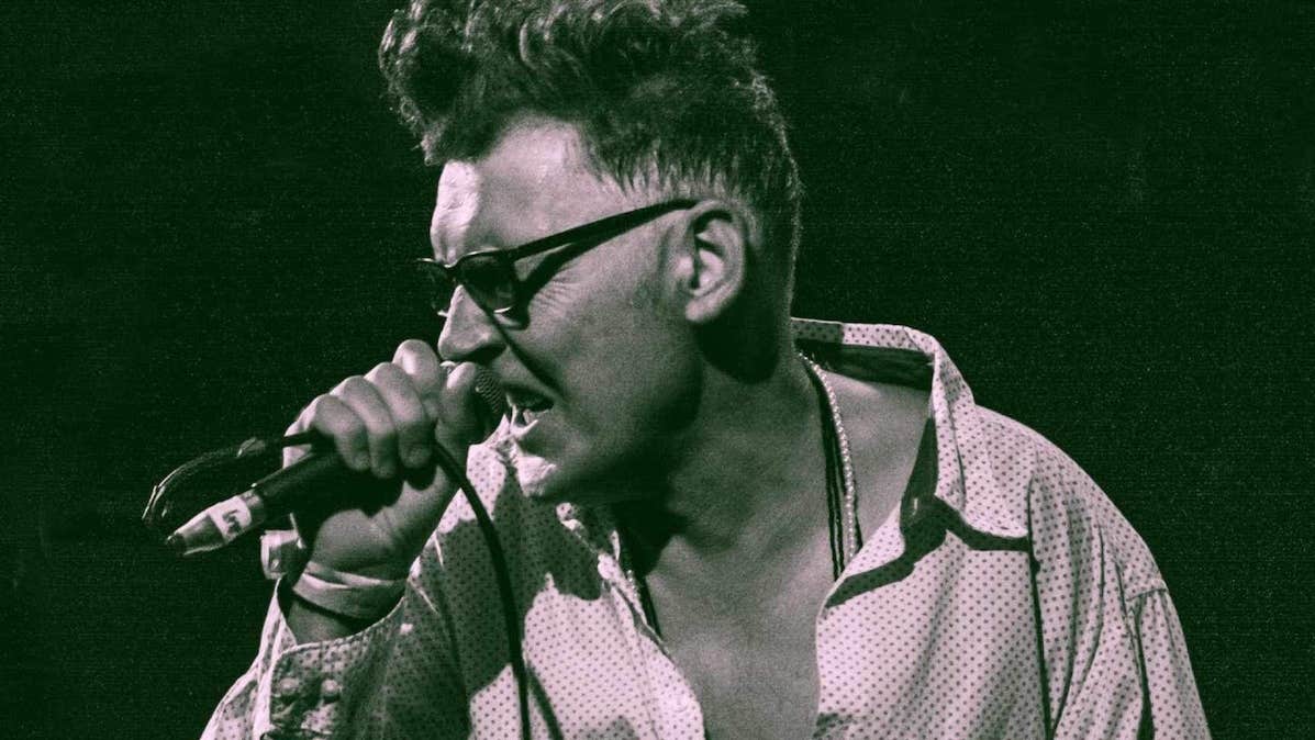 A man singing into a mic he's holding