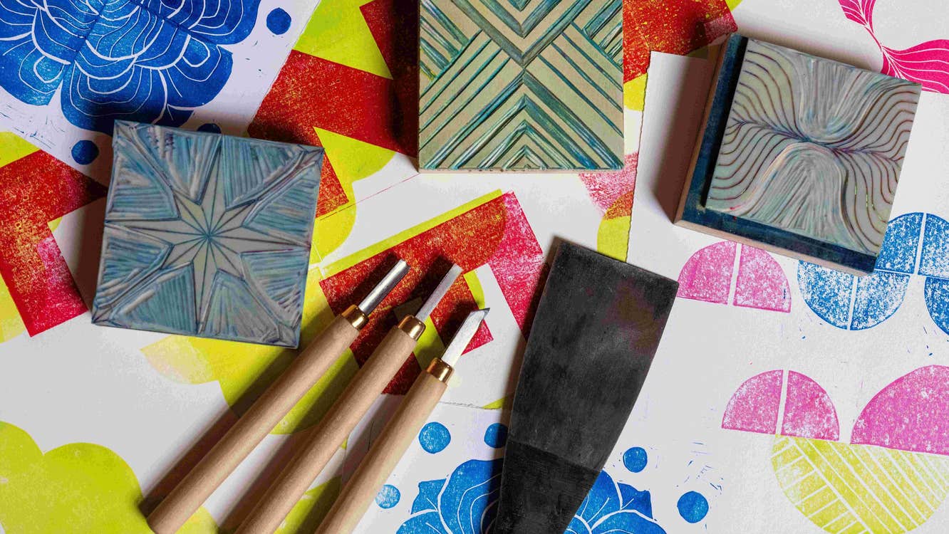 Print & Pattern with Susan Leen - Looking down at table containing print blocks, carving tools and paper with different coloured shapes on.
