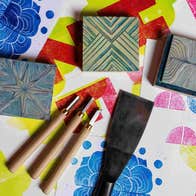 Print & Pattern with Susan Leen - Looking down at table containing print blocks, carving tools and paper with different coloured shapes on.