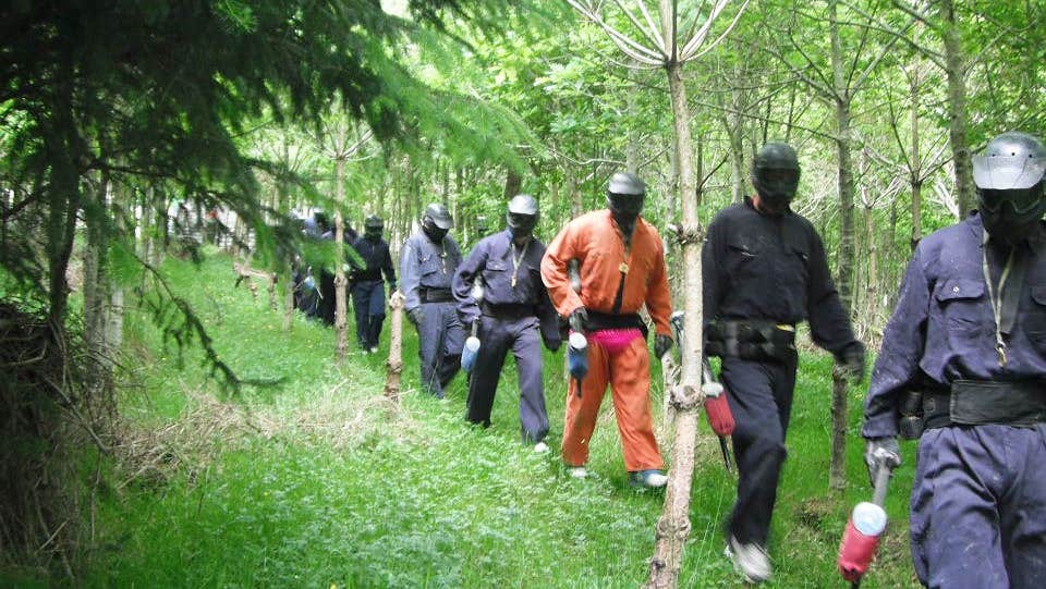 AWOL Outdoor Adventure people in paintball suits walking in the woods