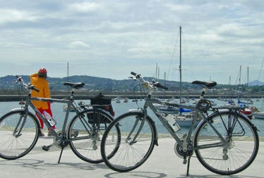 Irish Cycling Safaris view of bicycles next to a harbour with boats and hills in the background