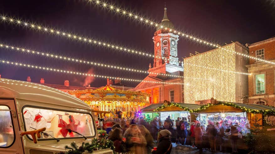 An out of focus shot of the Christmas market at Dublin Castle with Christmas lights strung everywhere and a merry-go-round.