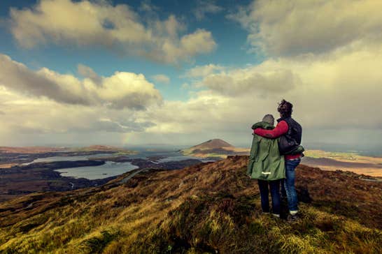 A couple on top of Diamond Hill overlooking Connemara National Park.