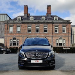 A luxury car parked in front of a large period building