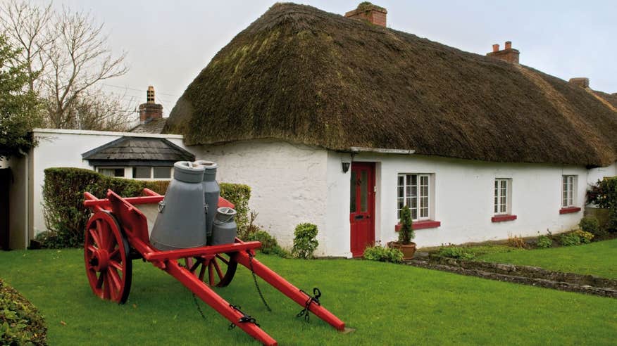 Green grass outside a thatched cottage in Adare, Co. Limerick
