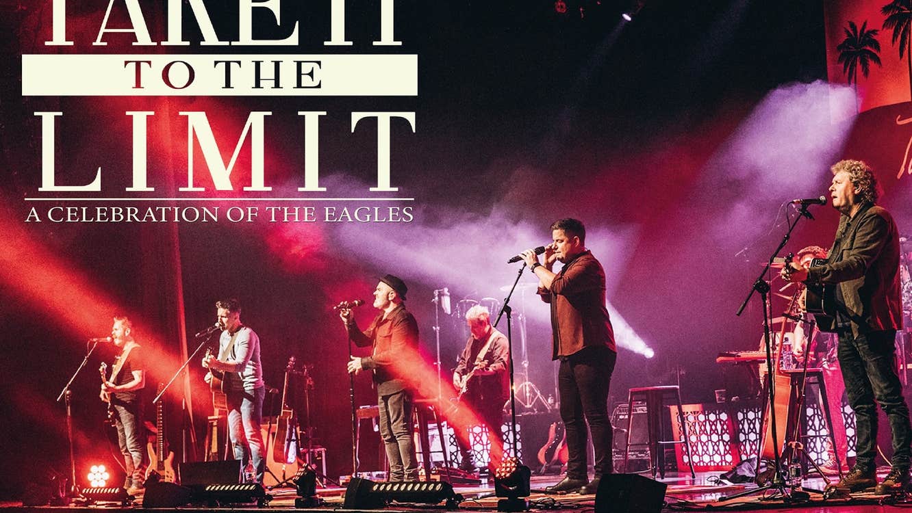 Red and purple lit stage with large group of musicians spread across the stage.