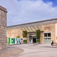 A courtyard entrance to a building with a large business logo outside
