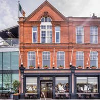 The exterior of a red brick building with glass extension and roof terrace
