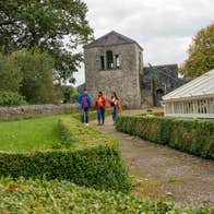 Three people walking through the grounds of Strokestown House and Park in County Roscommon.