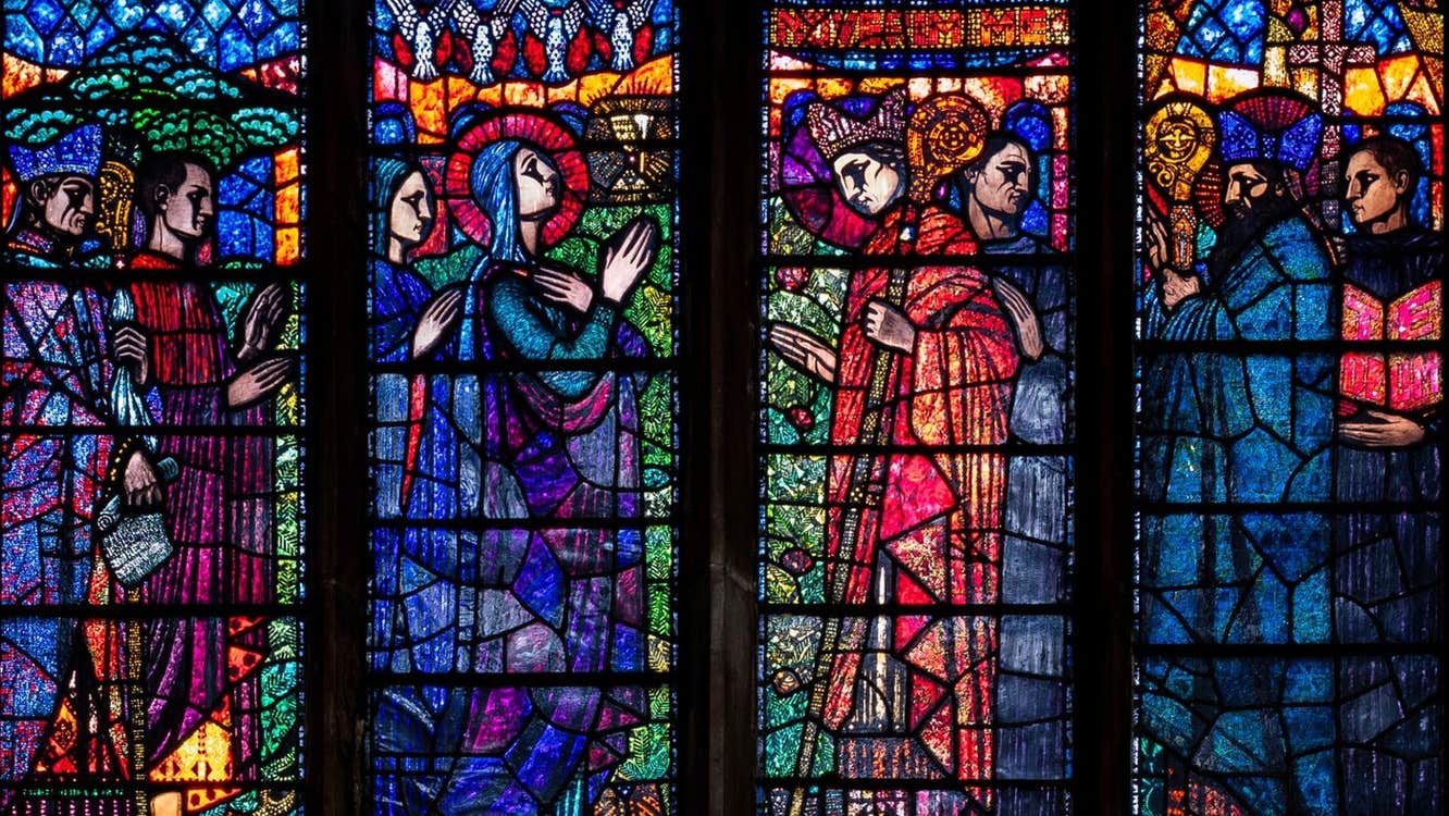 A stained glass window with colourful biblical scenes