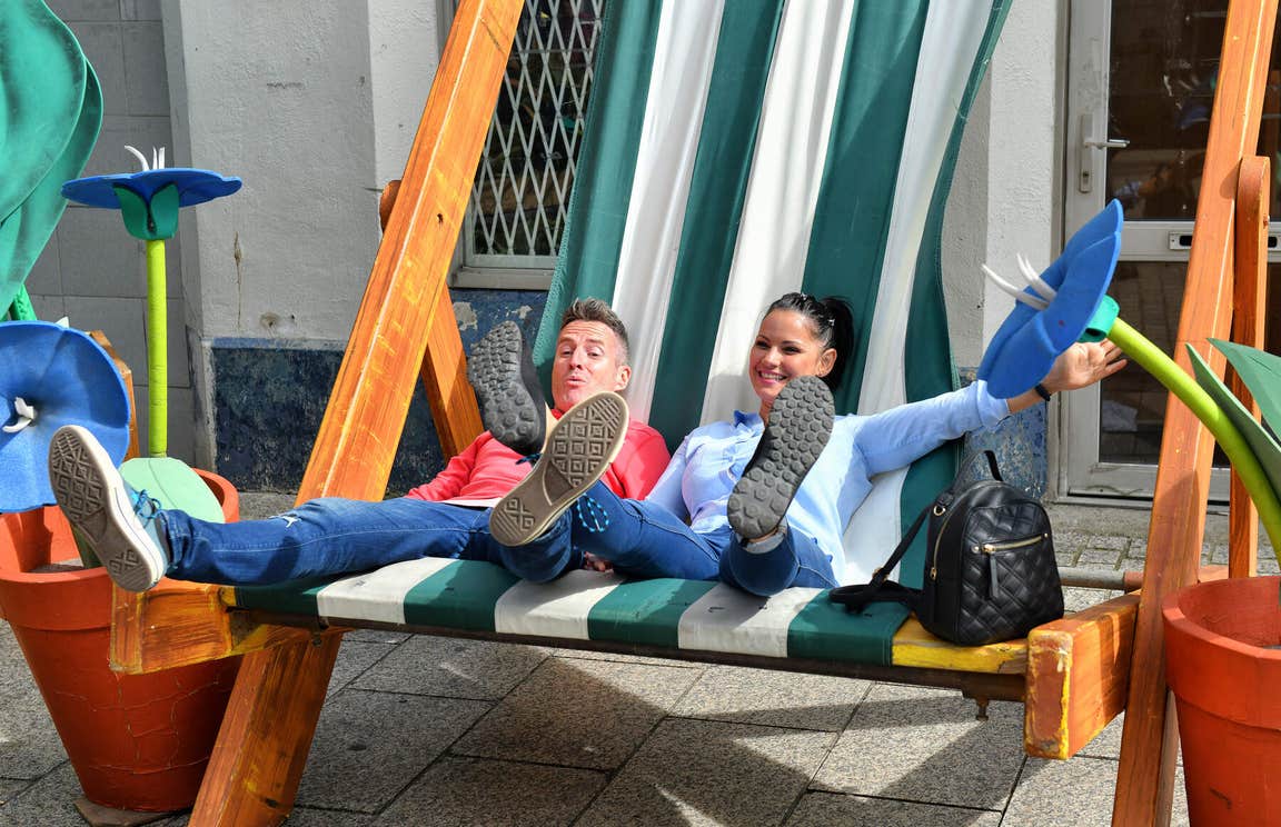 Smiling couple in Waterford City sharing a giant-sized beach chair.