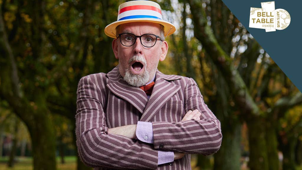 A man wearing a straw boater hat is looking shocked with mouth wide open and arms crossed in stripy blazer.