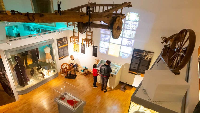 A view from the ceiling for the floor of the Tipperary Museum of Hidden History, with two people looking at a display