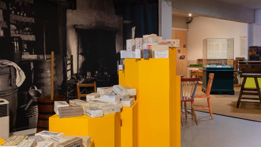 An exhibit in the Cork Butter Museum featuring displays of packaged butter alongside old equipment used in the production process