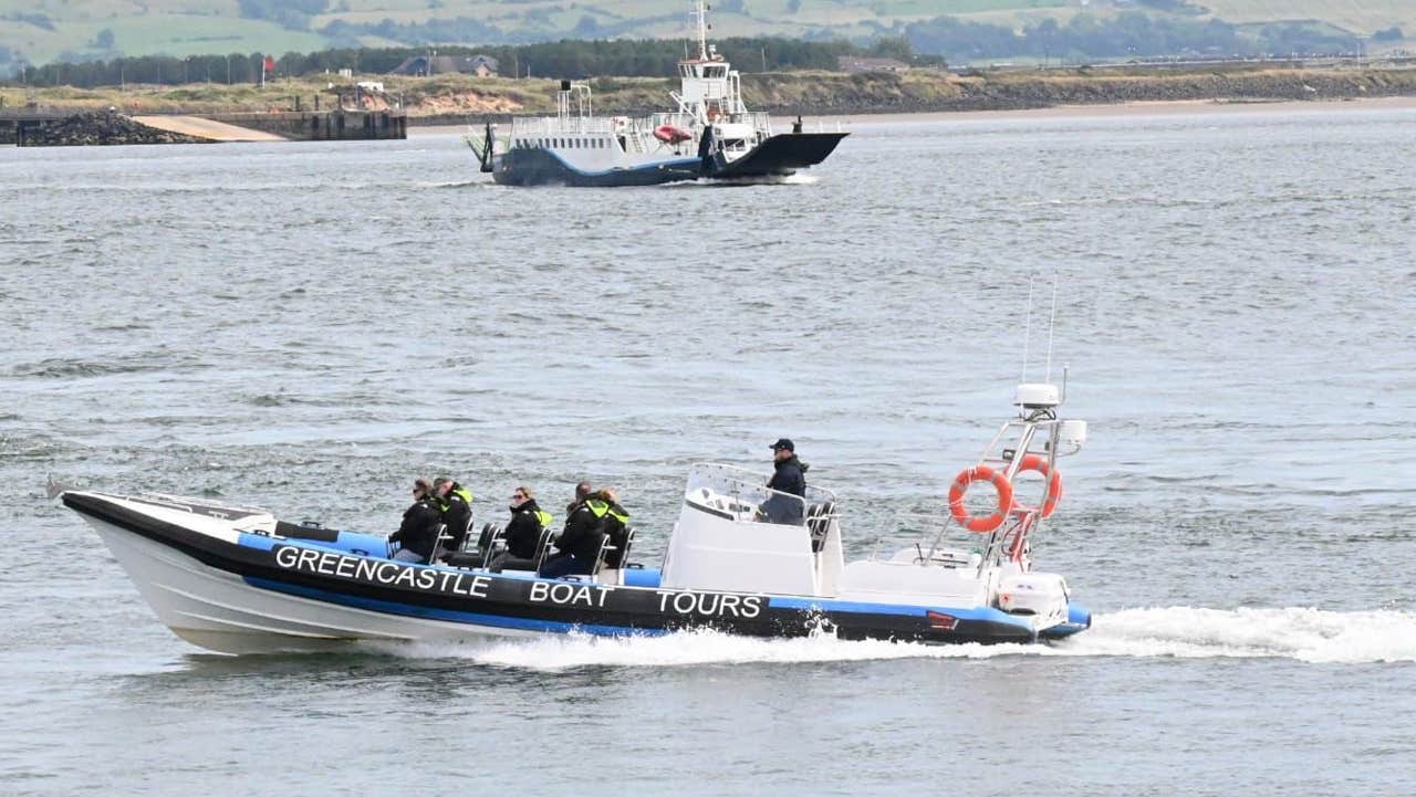 Greencastle Boat Tours out on tour with the ferry and the pier in the back ground