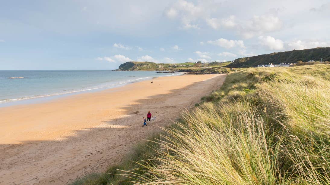 Two people walking down a quiet stretch of Culdaff Beach, County Donegal
