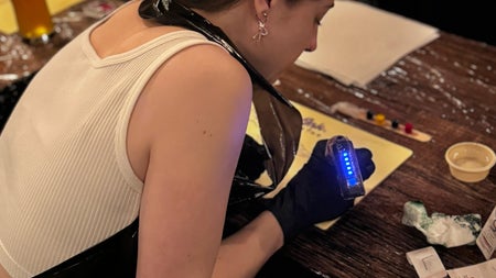 A guest leans in with full concentration, tattoo machine lit up and buzzing on practice skin. The perfect mix of focus, fun, and adrenaline at Dublin’s alternative art night.