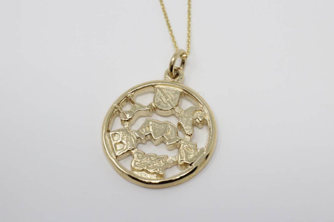 A gold pendant with symbols from traditional stories and mythology