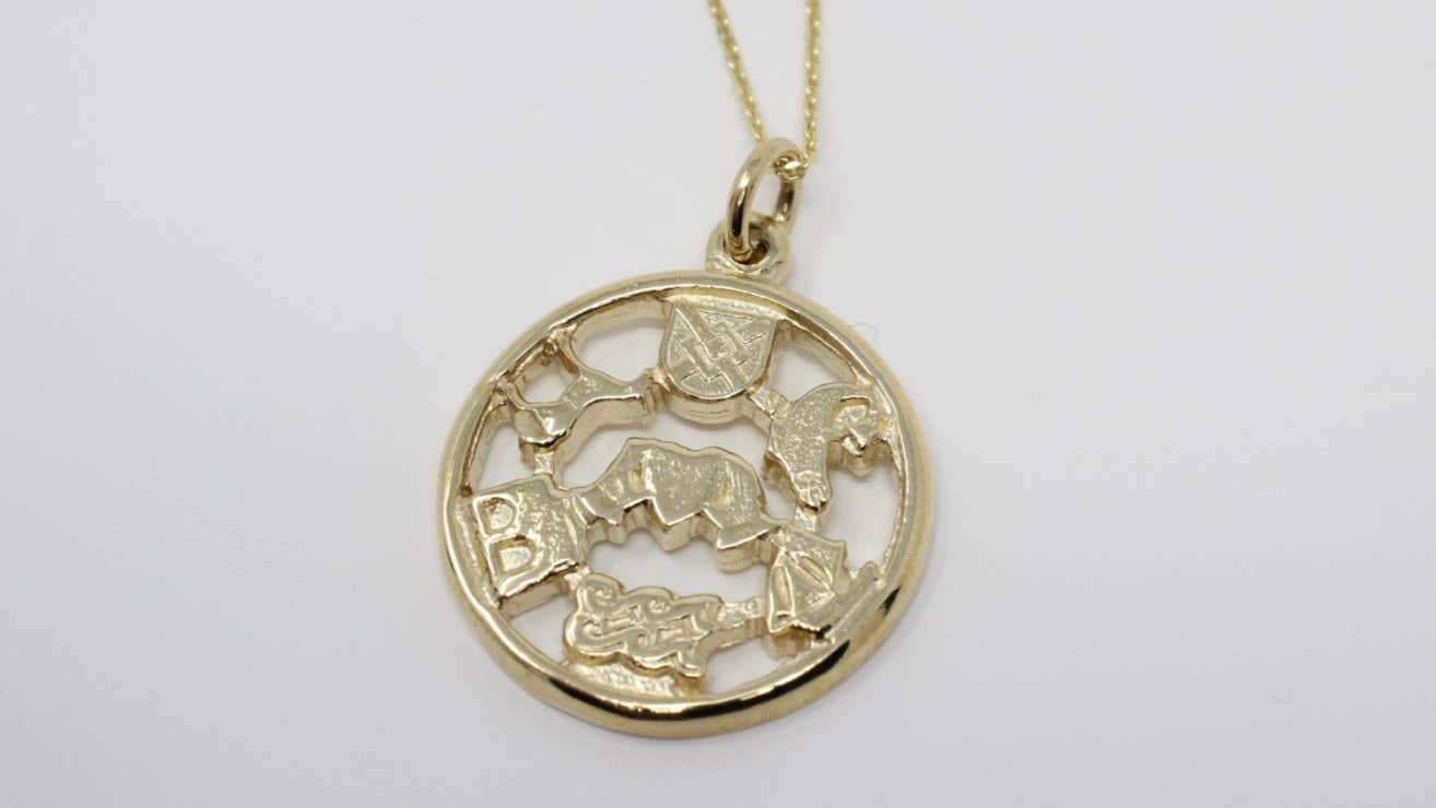 A gold pendant with symbols from traditional stories and mythology