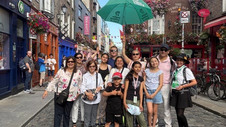 A group of people posing for the camera on a small city street
