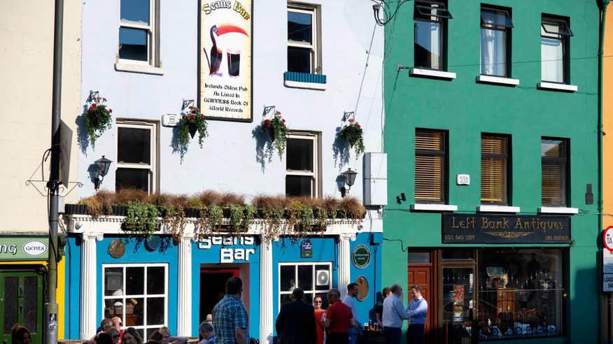 People standing outside Sean's Bar on a sunny day in Athlone, Westmeath