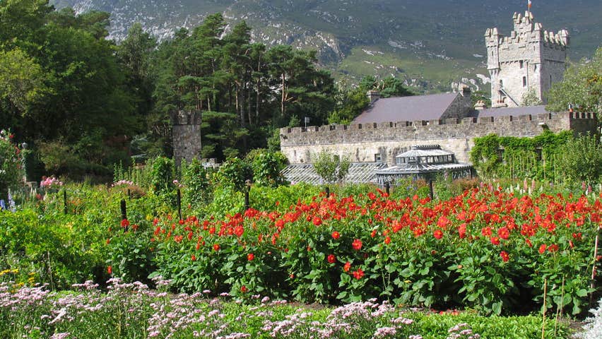 Glenveagh Castle surround by trees and colourful flowers