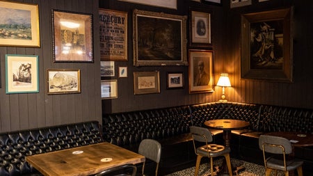 Dimly lit corner of a pub with tables and seating