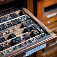 A case of wooden type partially pulled out of a type cabinet.