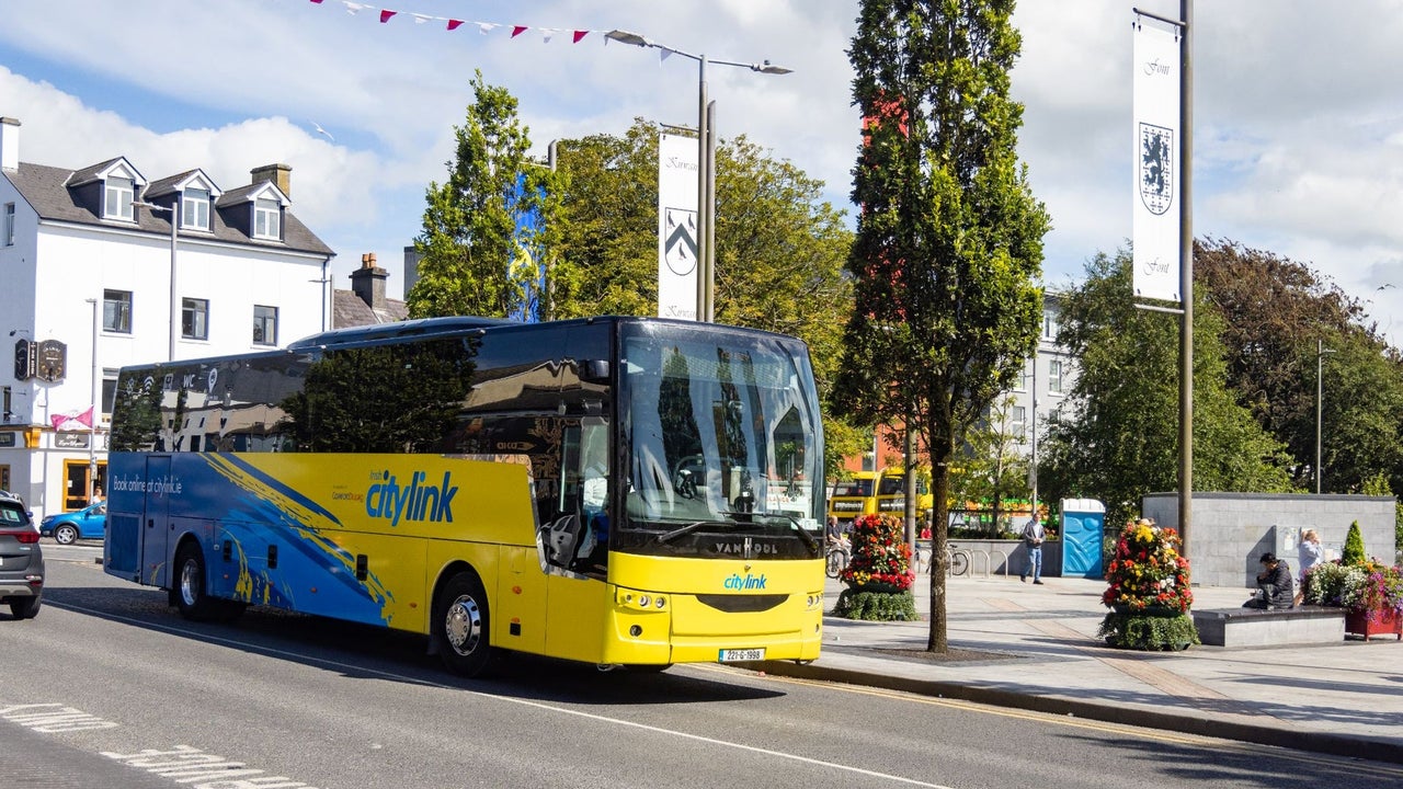 A blue and yellow coloured bus on a city street