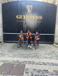 Three people on bikes outside Guinness storehouse gates