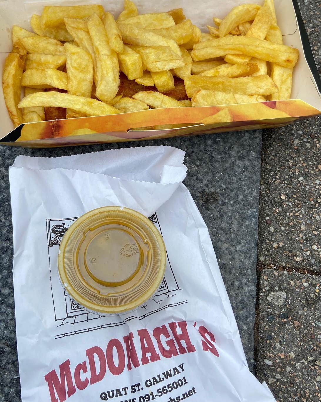 A container of chips with a tub of sauce