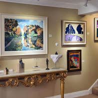 Image of six paintings on a wall and stairs on the right hand side
