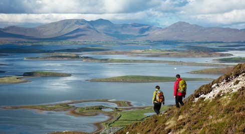 Two hikers on Croagh Patrick in Mayo near the waters of Clew Bay