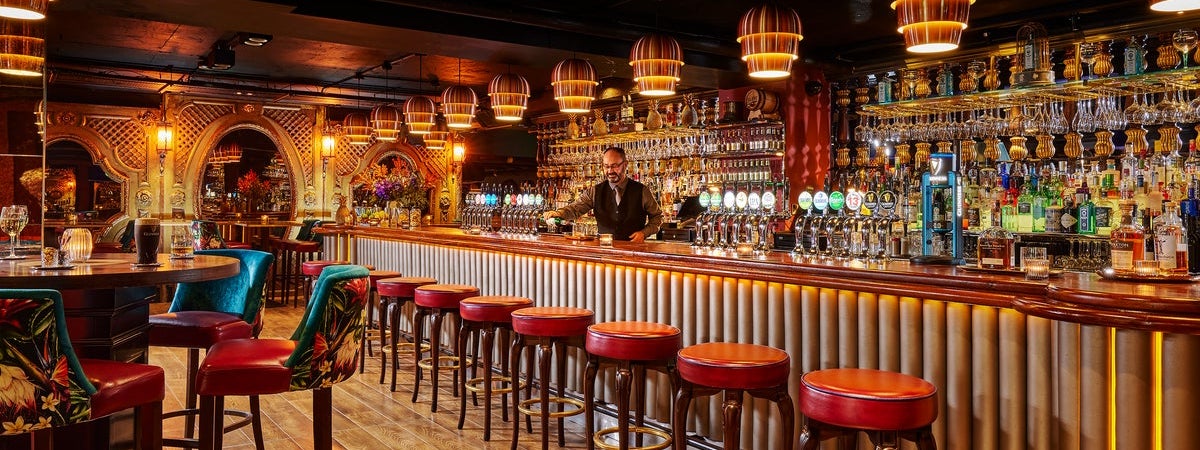 Barman pouring a drink at the bar in Bartleys